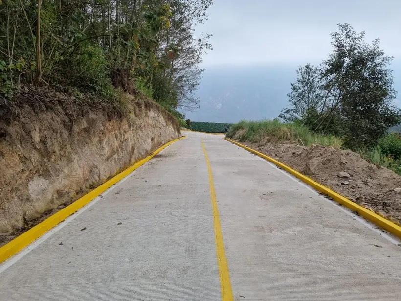 Camino rural pavimentado con bordillo amarillo